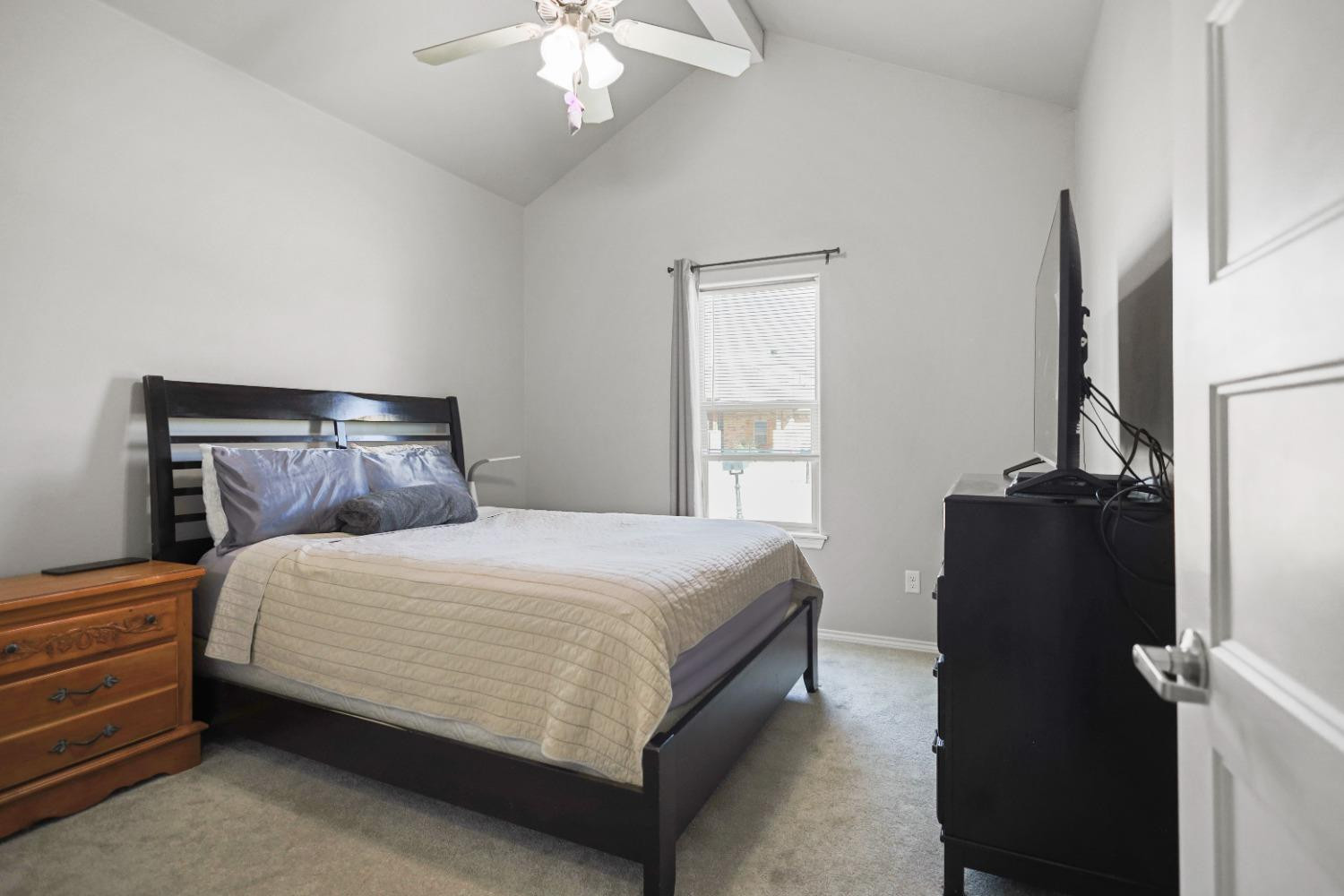 5227 Lehigh Street Lubbock, TX 79416 - Photo 17 of 33 a bedroom with a bed and a chandelier