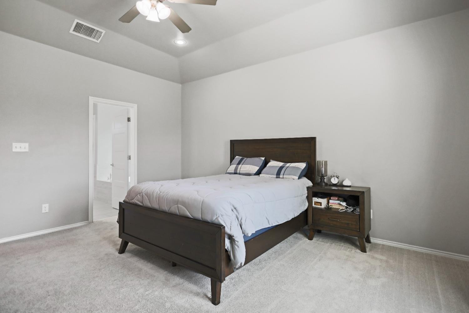 5227 Lehigh Street Lubbock, TX 79416 - Photo 20 of 33 a bedroom with a bed and a chandelier fan