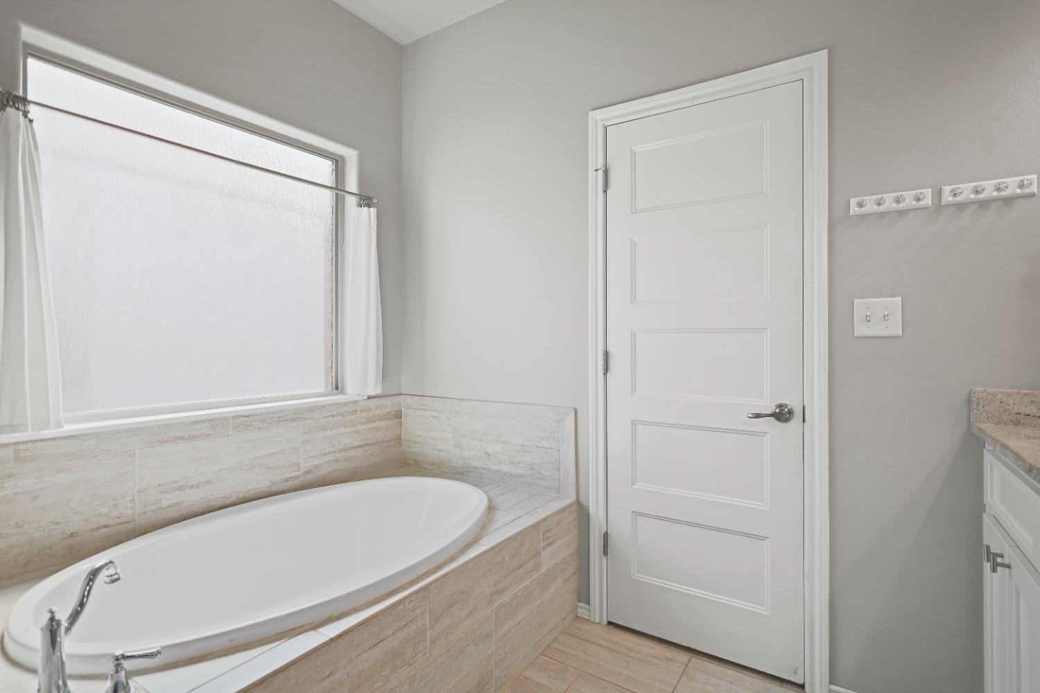 5227 Lehigh Street Lubbock, TX 79416 - Photo 22 of 33 a bathroom with a bathtub and a shower