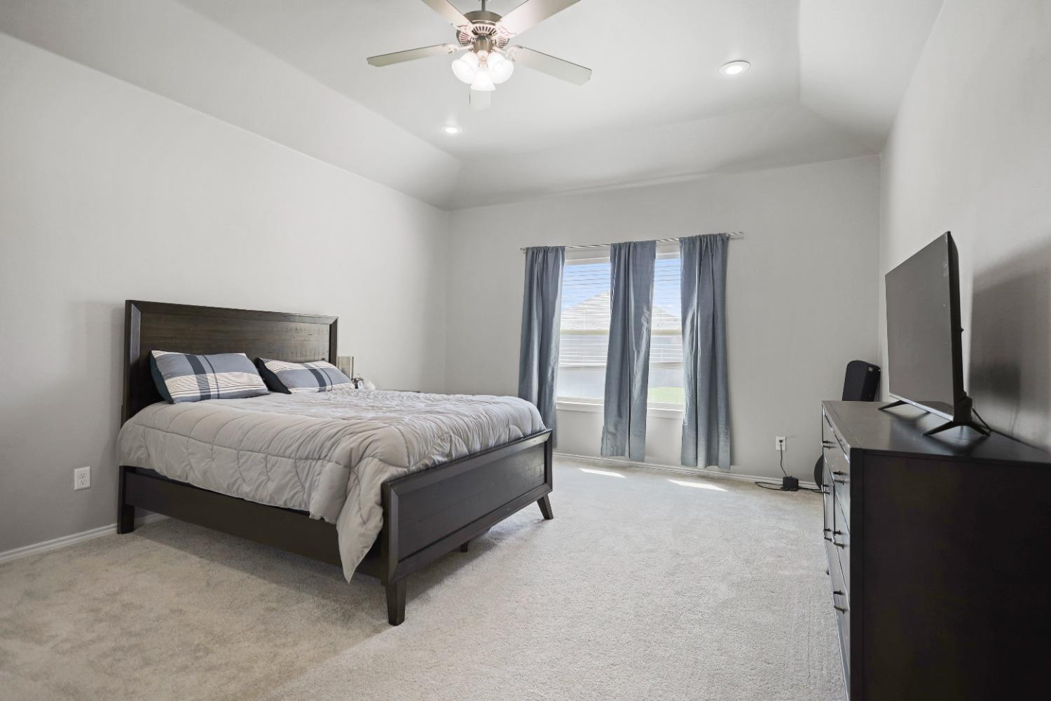 5227 Lehigh Street Lubbock, TX 79416 - Photo 3 of 33 a bedroom with a bed and a flat tv screen on dresser
