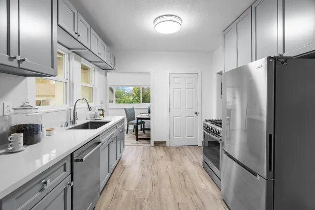 a kitchen with stainless steel appliances a refrigerator sink and cabinets