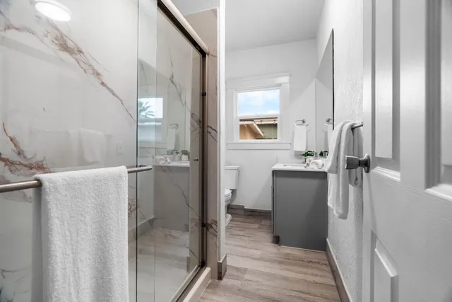 a bathroom with a glass door shower and a sink