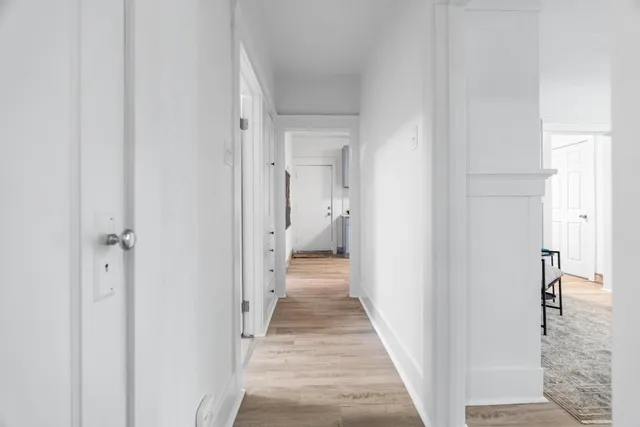 a view of a hallway with wooden floor and staircase