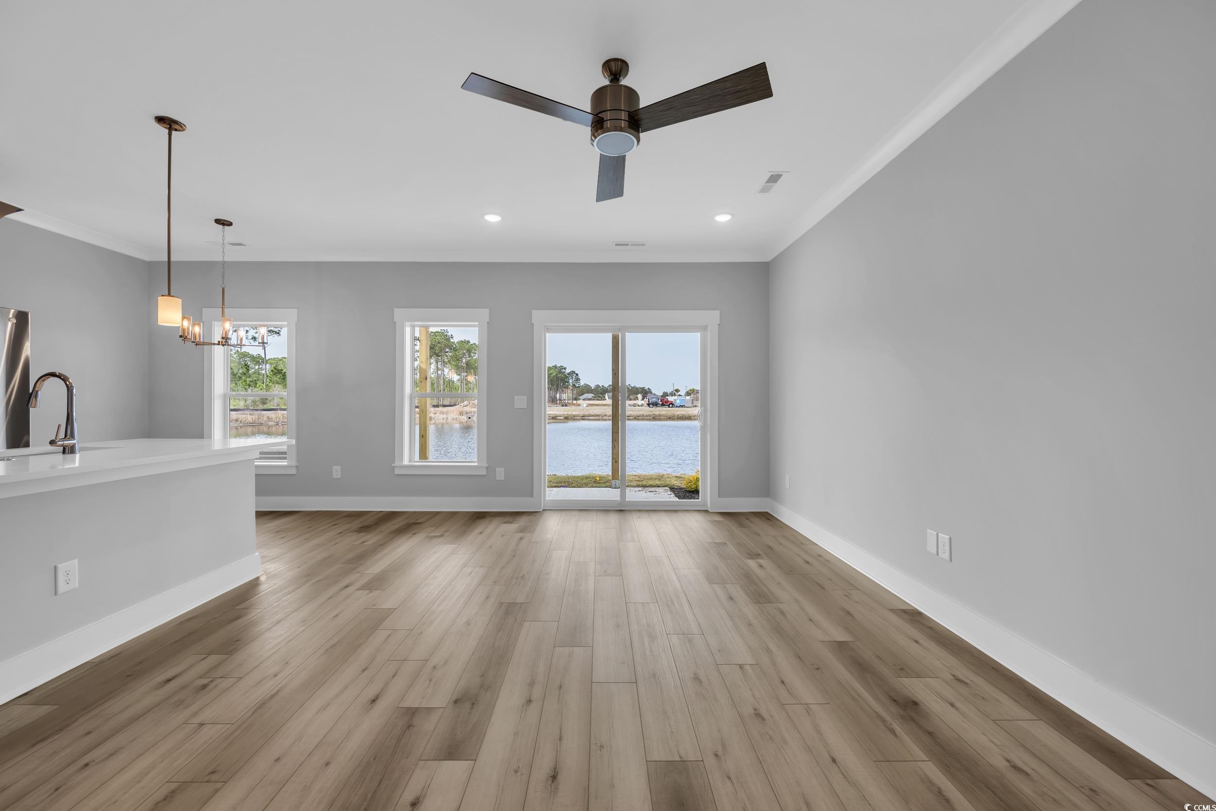 315 Lineback Place, Unit 37 Longs, SC 29568 - Photo 11 of 39 Unfurnished living room featuring baseboards, light wood-type flooring, and crown molding