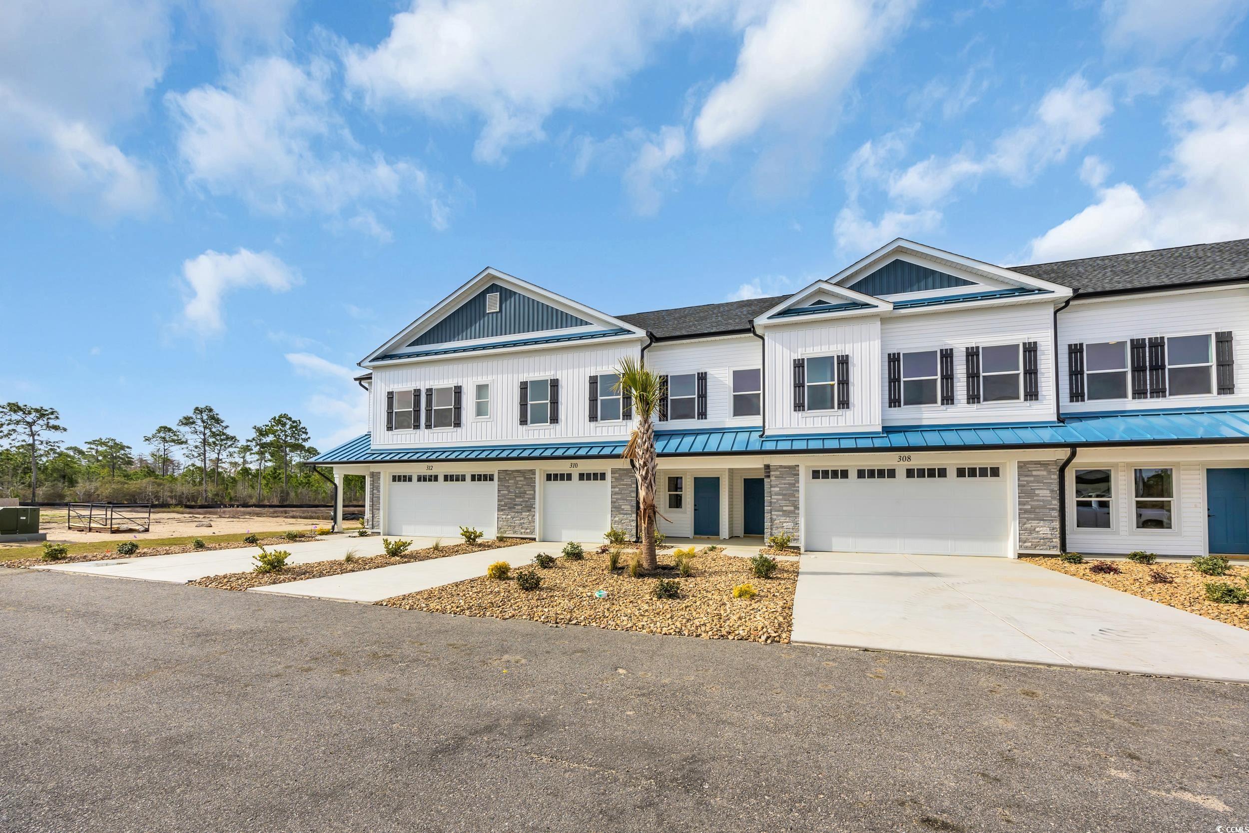 315 Lineback Place, Unit 37 Longs, SC 29568 - Photo 2 of 39 Townhome / multi-family property featuring driveway, a standing seam roof, stone siding, an attached garage, and metal roof