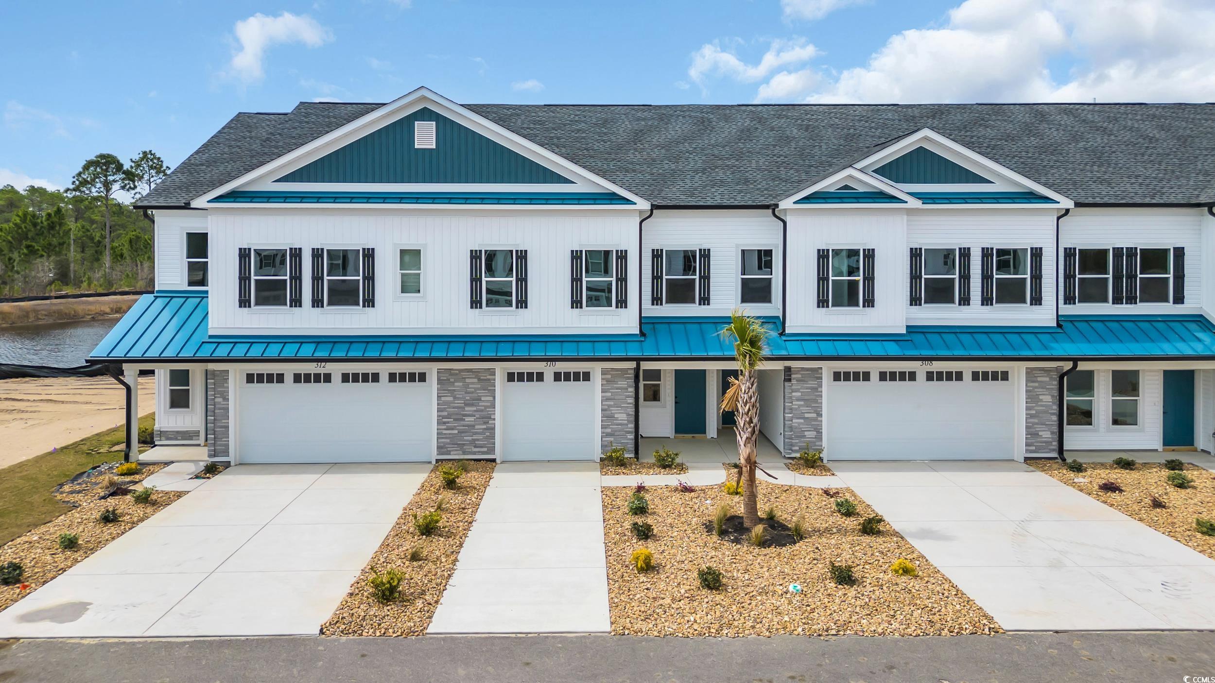 315 Lineback Place, Unit 37 Longs, SC 29568 - Photo 5 of 39 Townhome / multi-family property featuring stone siding, a garage, driveway, and a standing seam roof