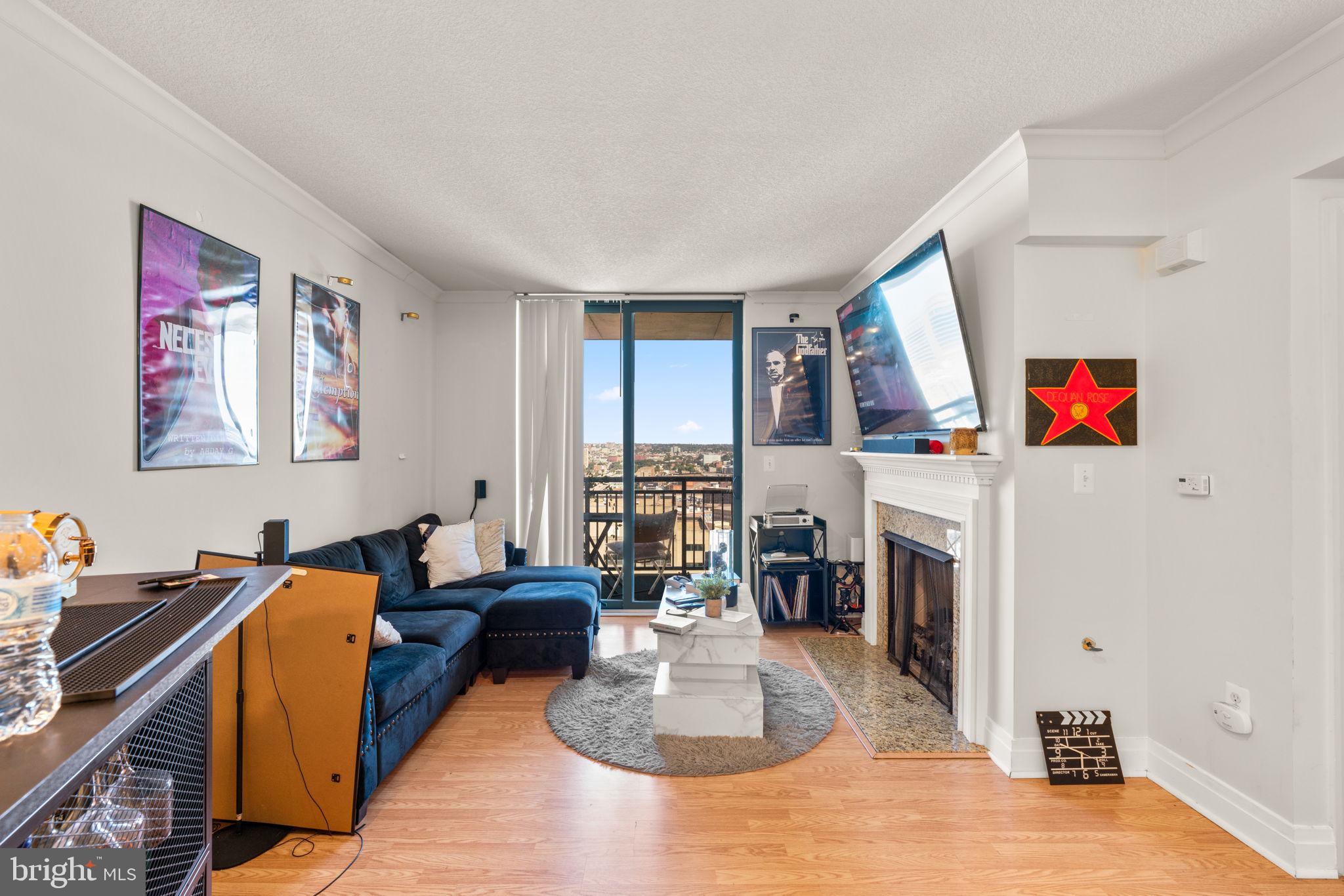 414 Water Street, Unit 2311 Baltimore, MD 21202 - Photo 12 of 44 a living room with furniture a fireplace and a table