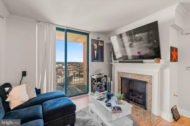 a living room with furniture large window and fireplace
