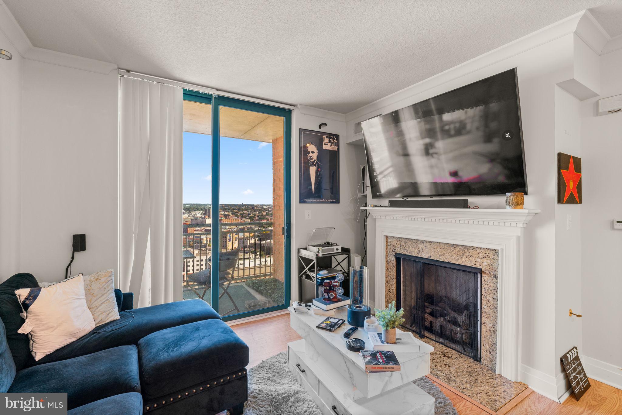 414 Water Street, Unit 2311 Baltimore, MD 21202 - Photo 13 of 44 a living room with furniture large window and fireplace