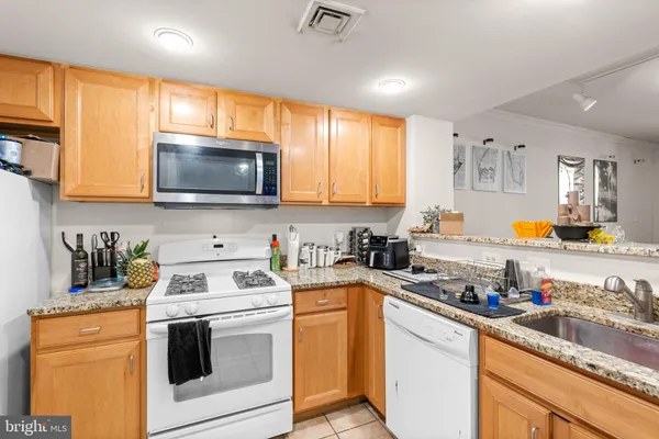 a kitchen with stainless steel appliances a stove a sink a stove a microwave cabinets and a window