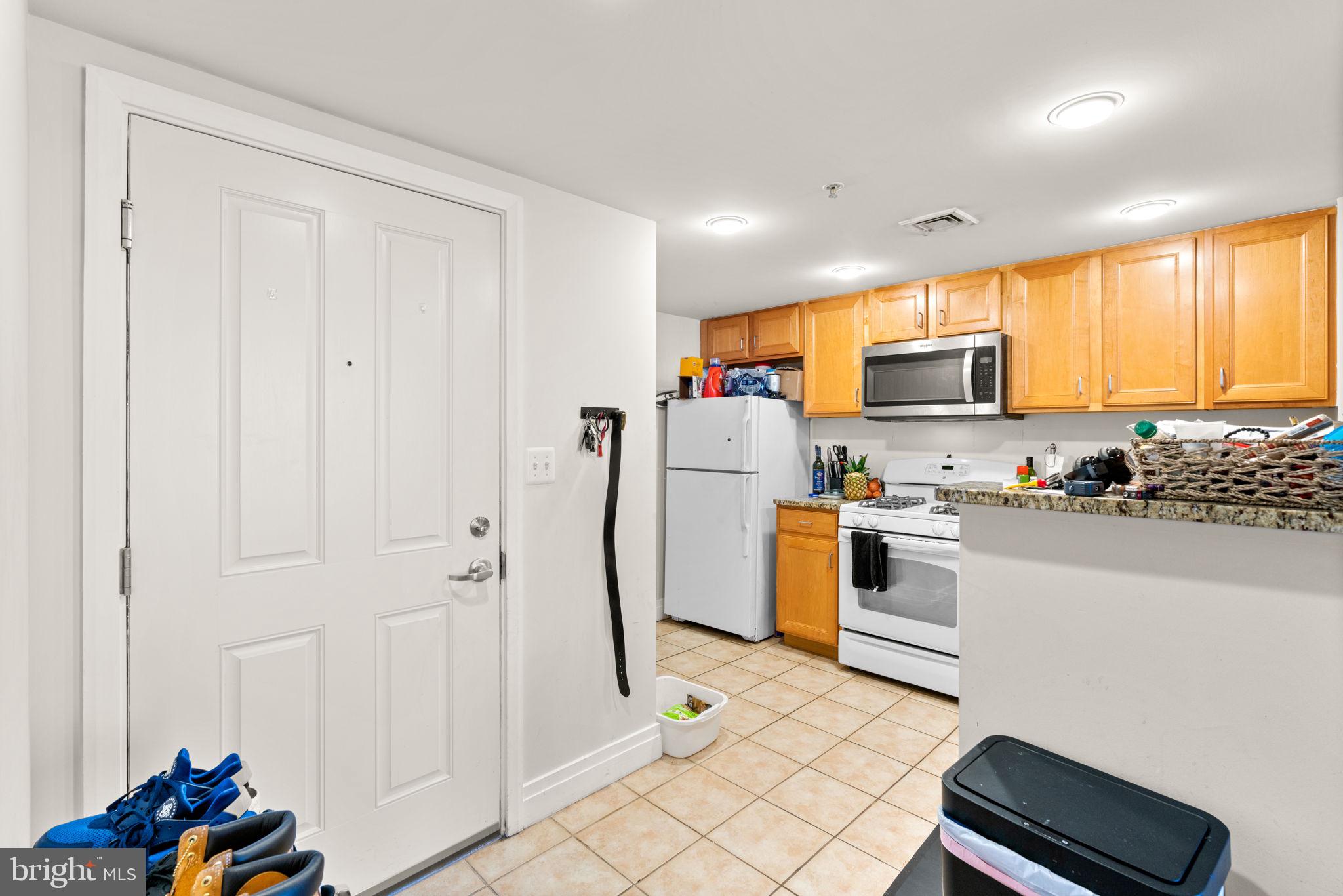 414 Water Street, Unit 2311 Baltimore, MD 21202 - Photo 22 of 44 a kitchen with stainless steel appliances a refrigerator a stove a sink dishwasher and a microwave