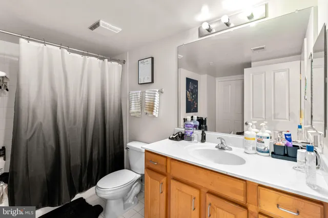 a bathroom with a double vanity sink toilet and a mirror