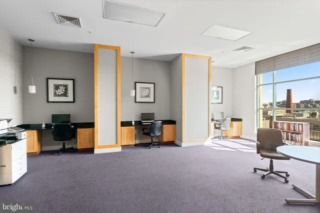 a view of a livingroom with workspace and a window