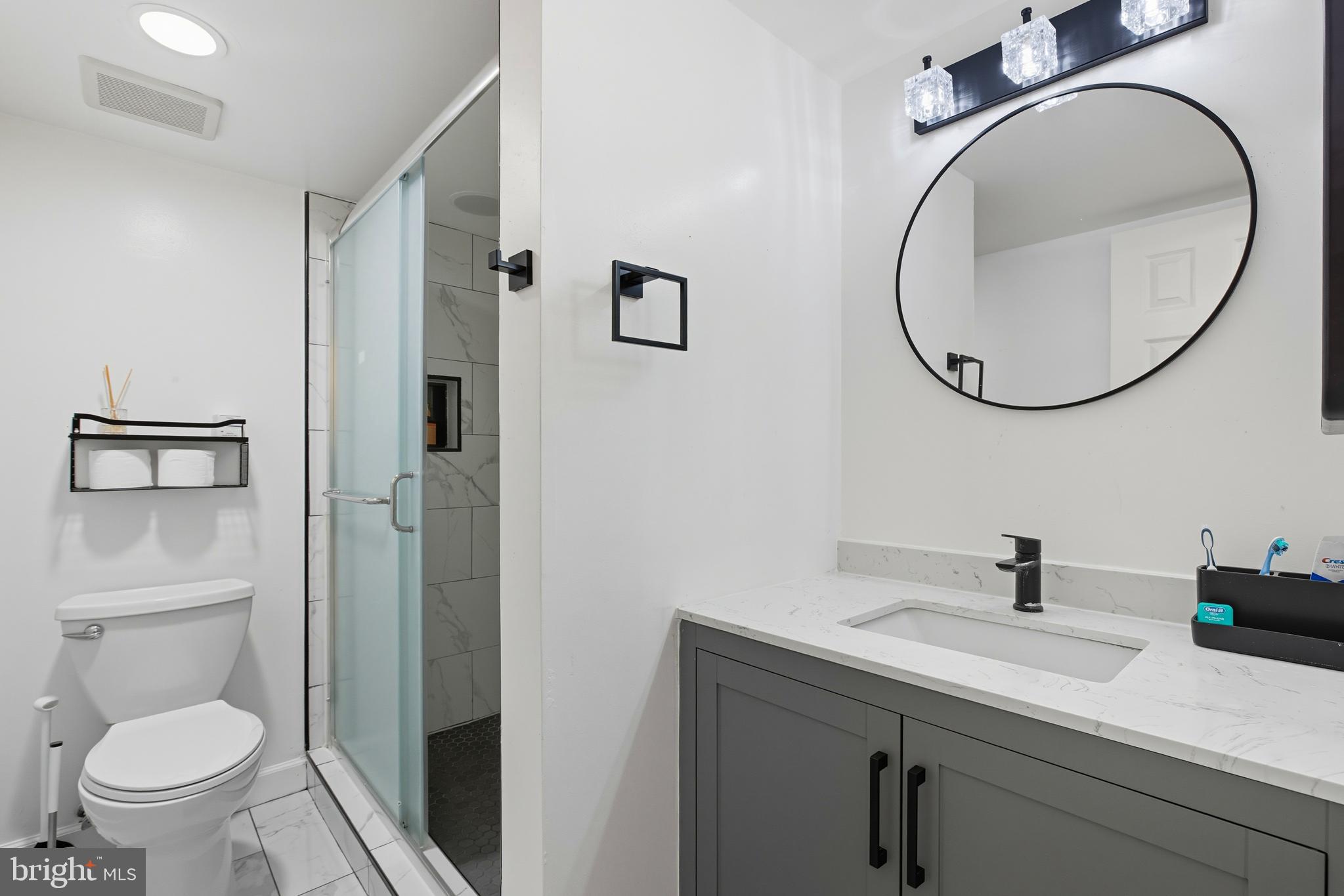 11430 Strand Drive, Unit R203 Rockville, MD 20852 - Photo 16 of 31 a bathroom with a toilet a sink and a mirror