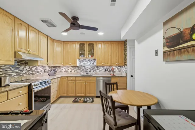 a kitchen with a table chairs stove and cabinets