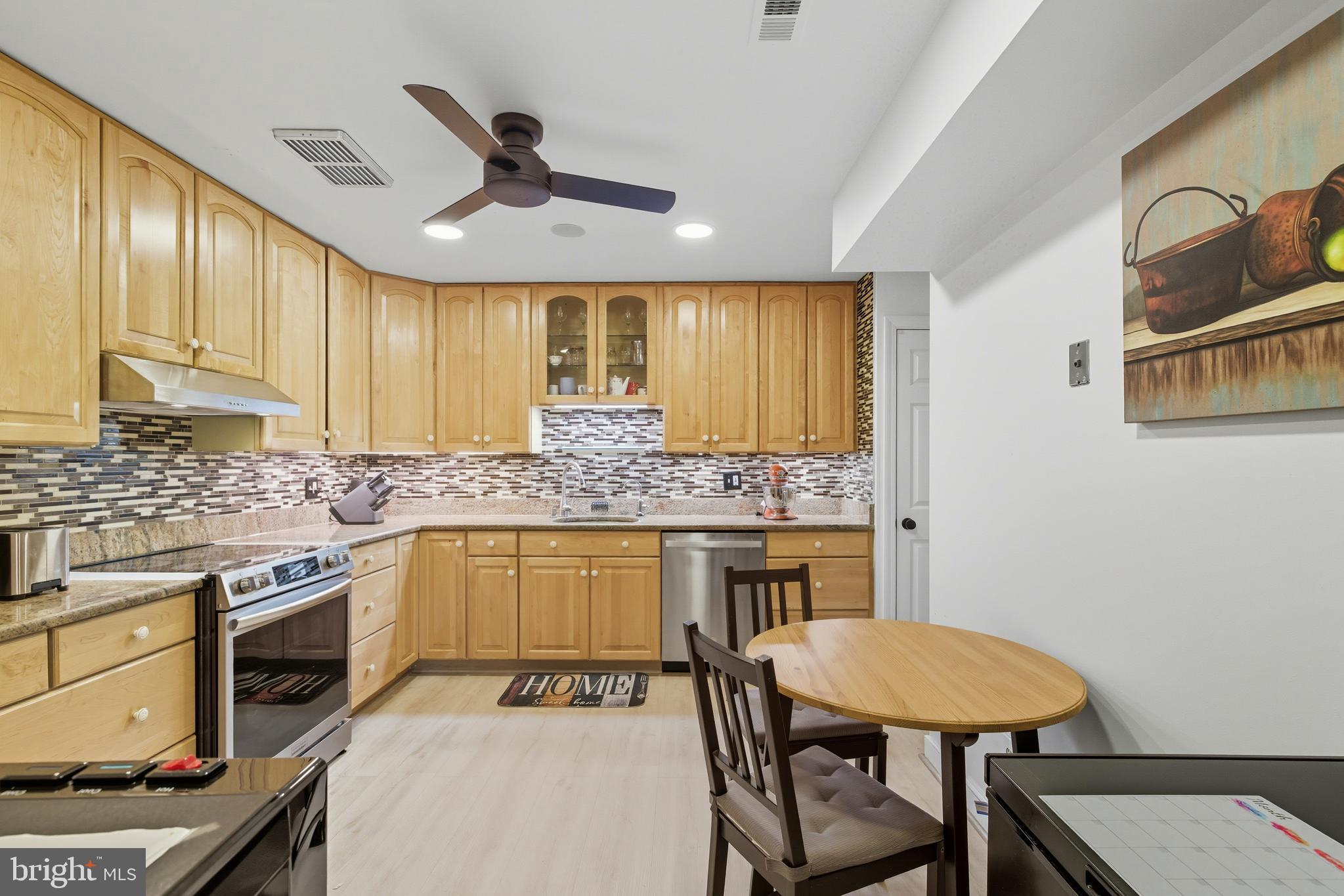 11430 Strand Drive, Unit R203 Rockville, MD 20852 - Photo 4 of 31 a kitchen with a table chairs stove and cabinets