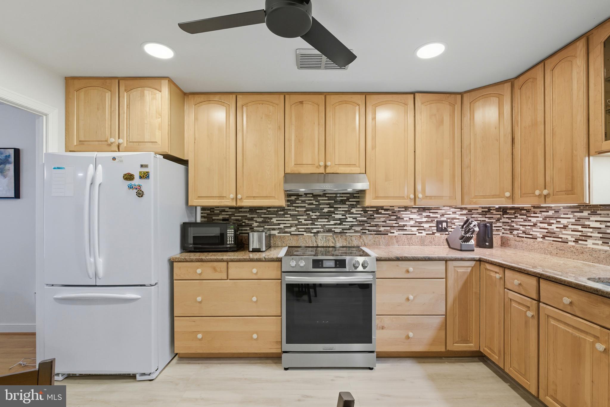 11430 Strand Drive, Unit R203 Rockville, MD 20852 - Photo 7 of 31 a kitchen with a refrigerator sink and cabinets