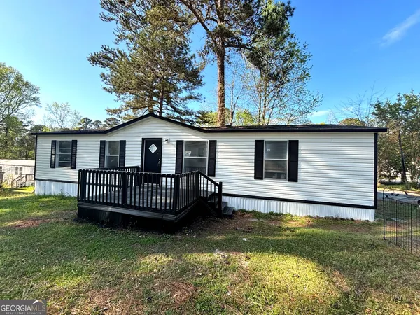 a view of a house with a wooden deck and a yard