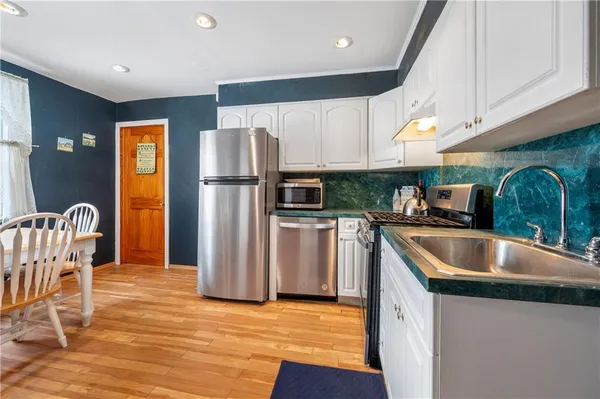 a kitchen with stainless steel appliances granite countertop a refrigerator a sink a stove and island