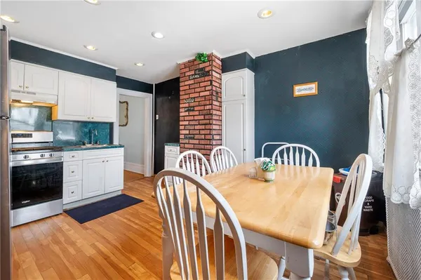 a kitchen with stainless steel appliances granite countertop a stove a sink a dining table and chairs