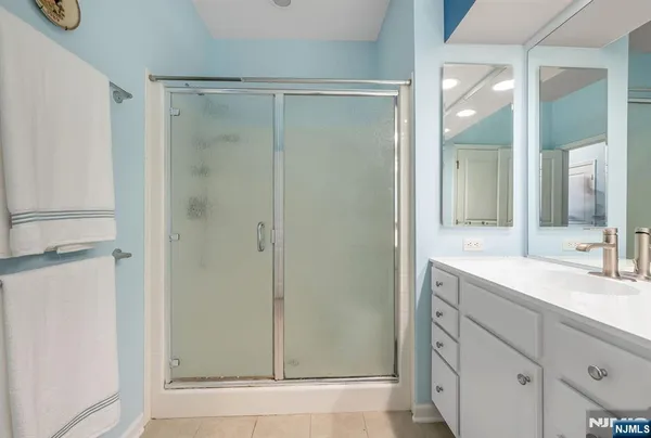 a bathroom with a shower sink and mirror
