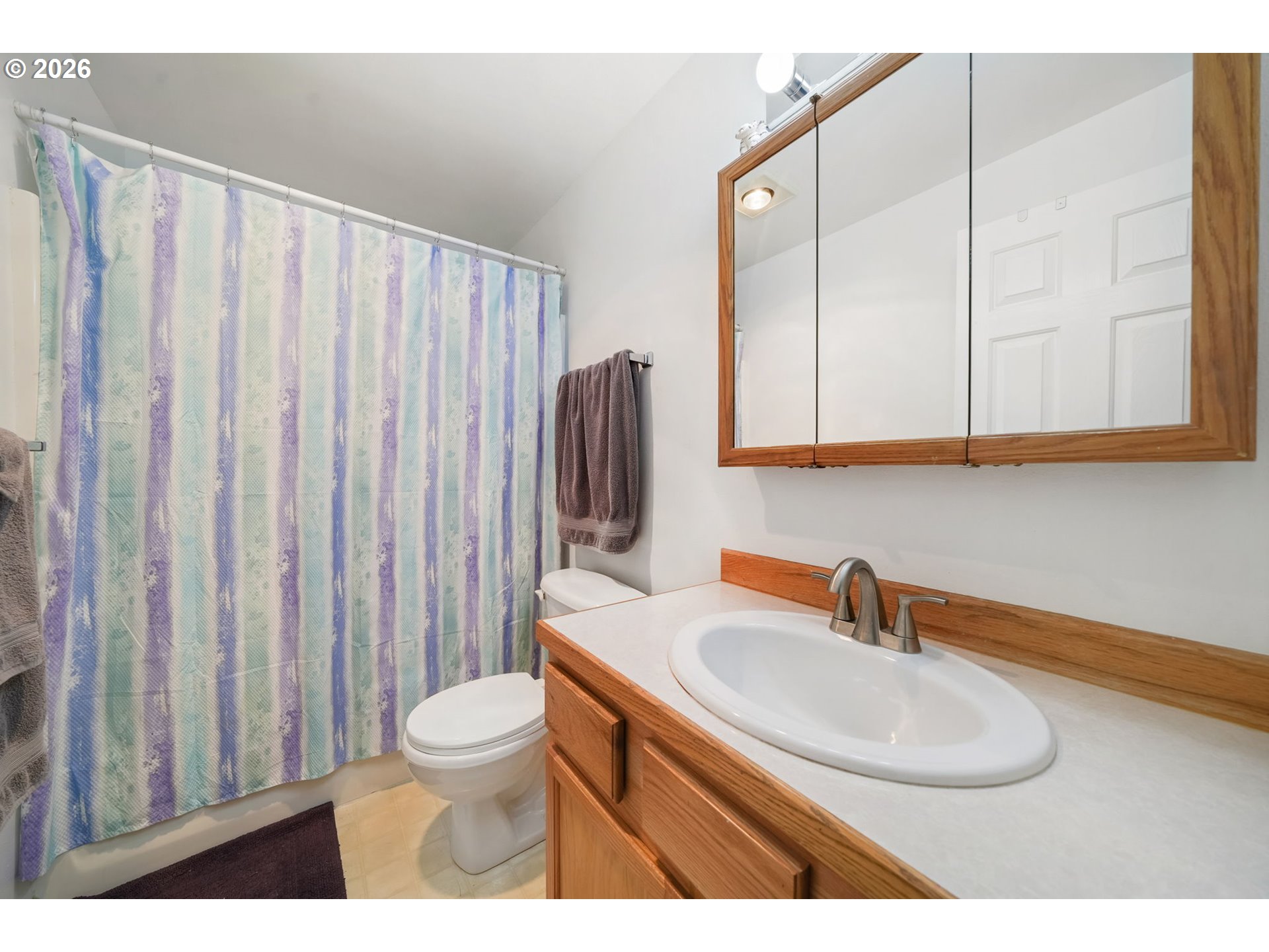 2102 South 8th Street Cottage Grove, OR 97424 - Photo 20 of 28 a bathroom with a sink a toilet and a mirror