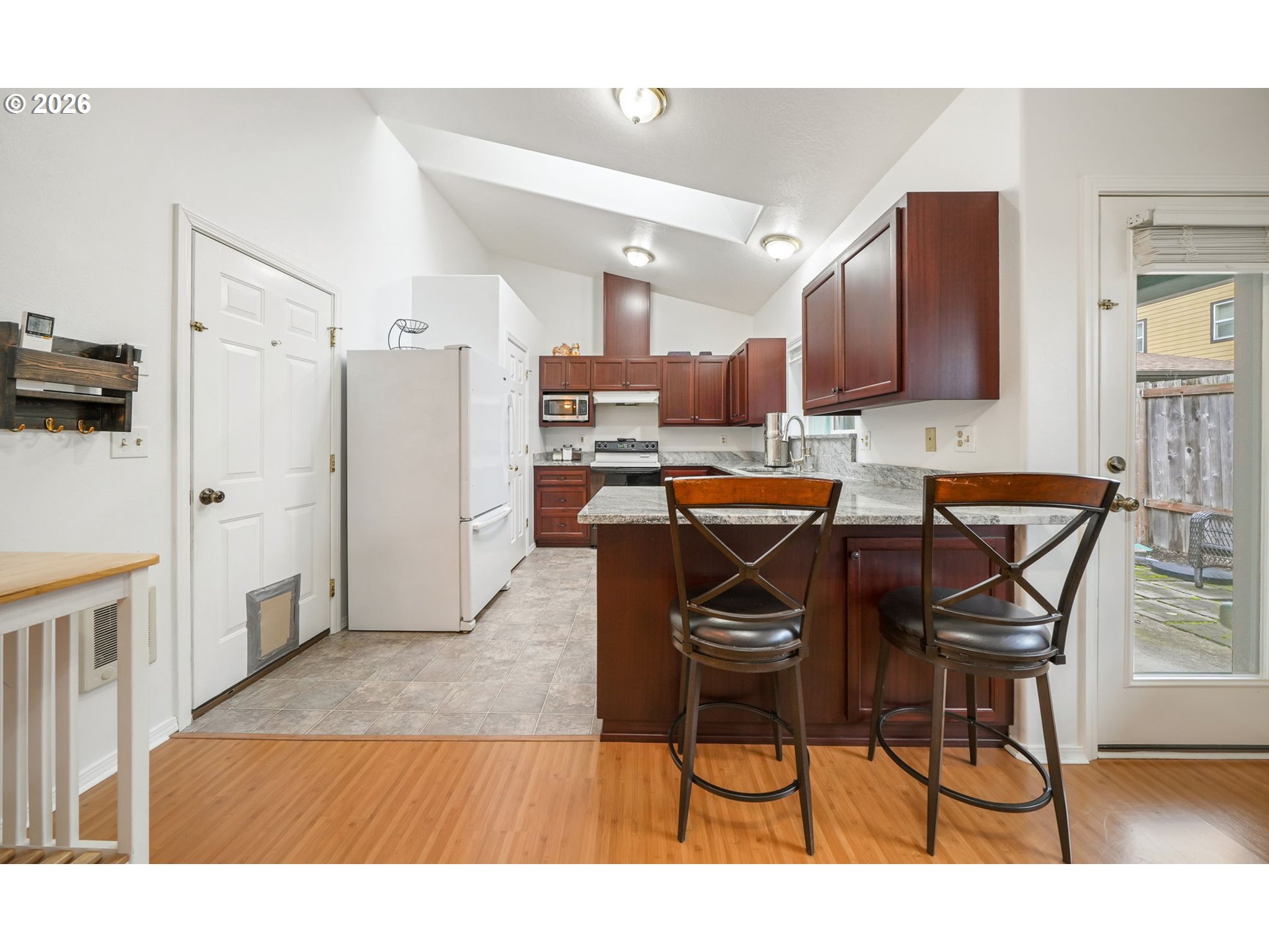 2102 South 8th Street Cottage Grove, OR 97424 - Photo 10 of 28 a open kitchen with stainless steel appliances kitchen island granite countertop a refrigerator and microwave