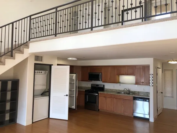 a kitchen with stainless steel appliances kitchen island granite countertop a refrigerator and a stove