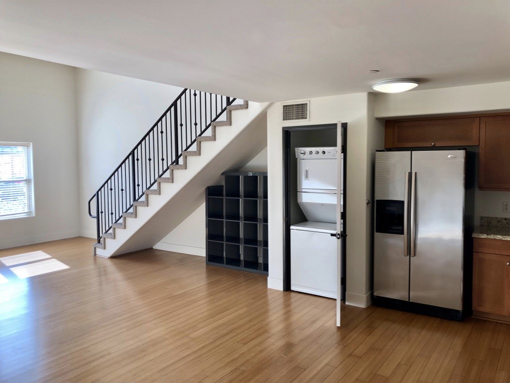 255 West 7th Street, Unit 20 San Pedro, CA 90731 - Photo 5 of 13 a view of a livingroom with wooden floor staircase and kitchen space a refrigerator