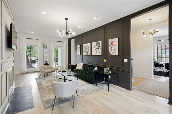a living room with furniture a chandelier and a flat screen tv