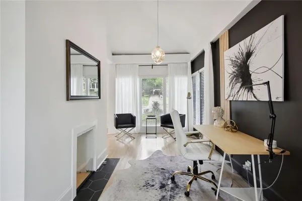 a living room with furniture a table and paintings on the wall