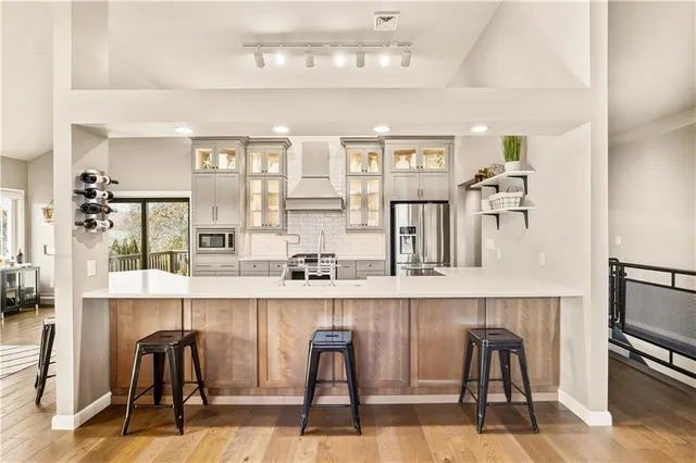 a kitchen with stainless steel appliances kitchen island granite countertop a refrigerator and cabinets