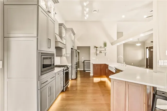 a kitchen with stainless steel appliances kitchen island granite countertop a refrigerator and a sink