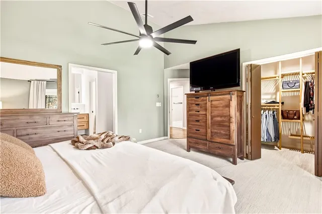 a bedroom with a bed a flat screen tv and a dresser