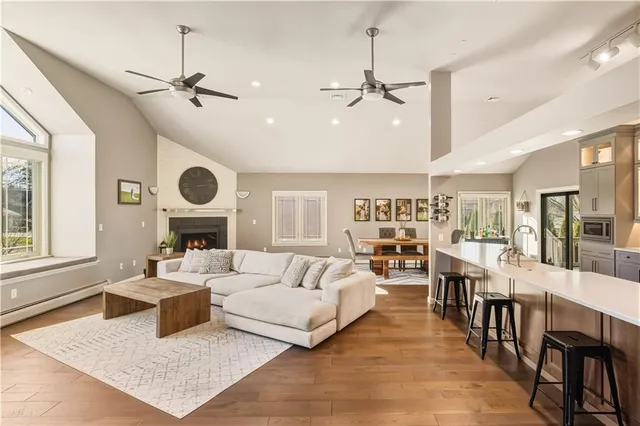 a living room with furniture kitchen view and a large window