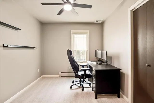 a workspace with chandelier a rug and a window