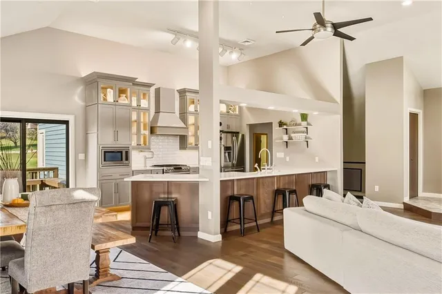 a living room with couches a coffee table and chandelier