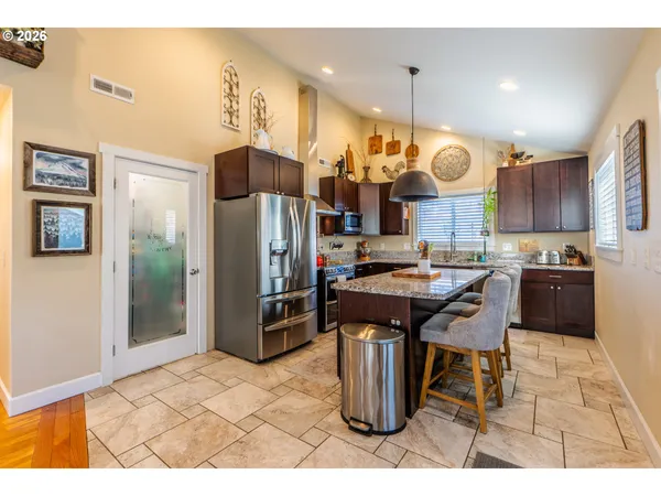 a kitchen with stainless steel appliances granite countertop a sink a stove and a refrigerator