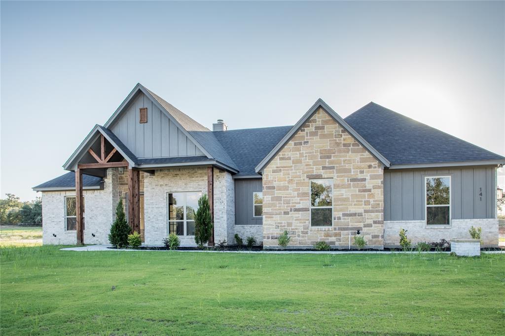 141 Prairie Winds Drive Poolville, TX 76487 - Photo 2 of 15 a front view of a house with a garden