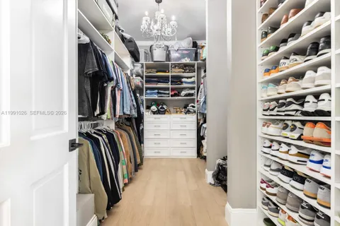 a view of walk in closet with clothes and shoes