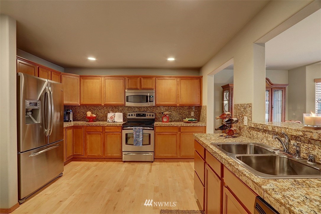 105 196th Place Southwest Bothell, WA 98012 - Photo 4 of 18 a kitchen with stainless steel appliances granite countertop a refrigerator sink and stove