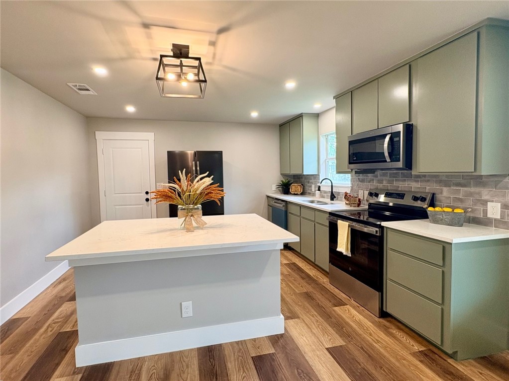 102 Terral Court Cameron, TX 76520 - Photo 4 of 14 a large white kitchen with kitchen island a sink stainless steel appliances and cabinets