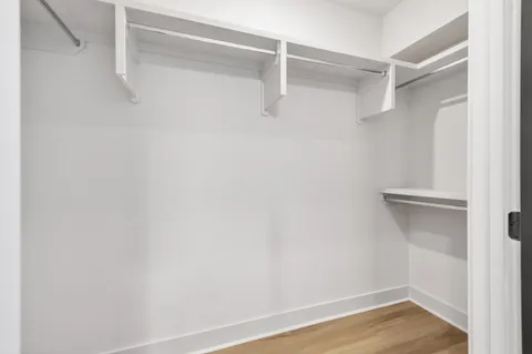 an empty room with a window and wooden floor