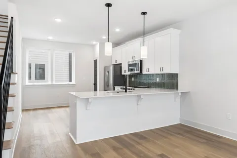 a kitchen with kitchen island a sink appliances and cabinets