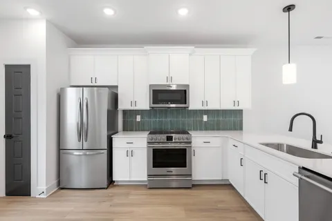 a kitchen with stainless steel appliances a refrigerator sink and microwave