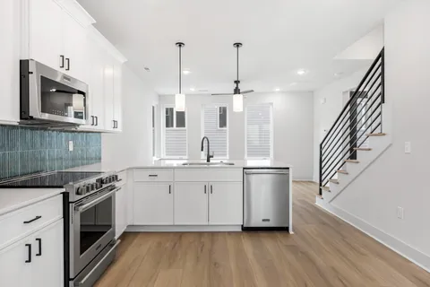 a kitchen with stainless steel appliances a stove a sink and a wooden floors