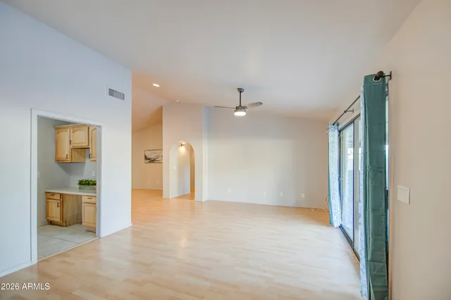 a view of a hallway with wooden floor and a bathroom
