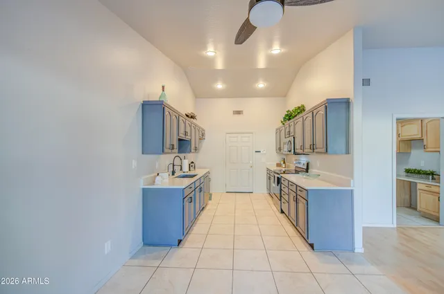 a large kitchen with stainless steel appliances a sink and cabinets