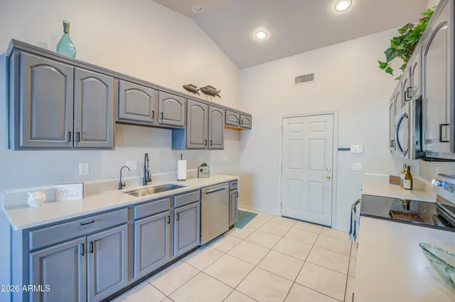 a kitchen with a sink cabinets and wooden floor