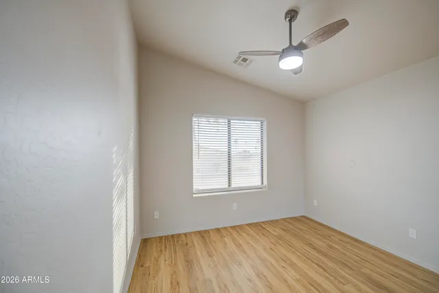 an empty room with a window and a fan